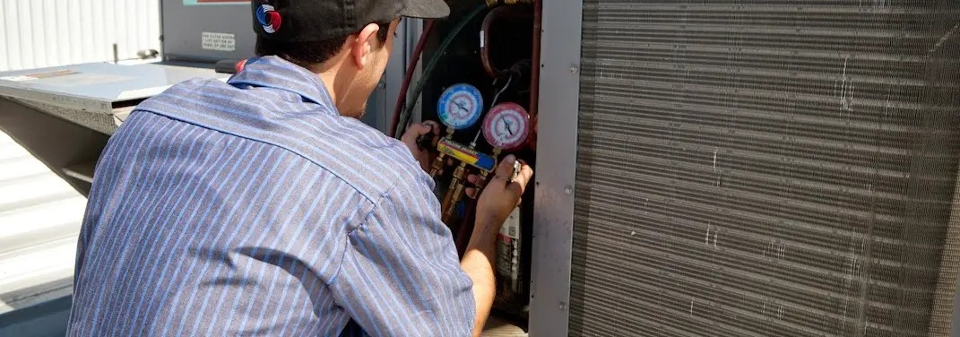 HVAC technician servicing a condenser unit in Venus