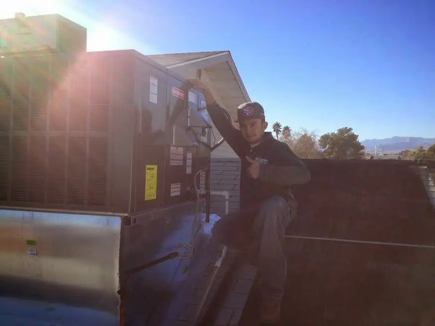 HVAC technician performing AC Tune-Up on a rooftop unit in Venus